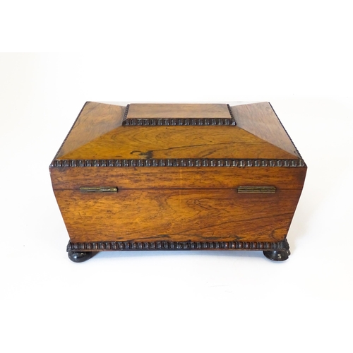 1194 - A Victorian rosewood sewing box / workbox of sarcophagus form with twin ring handles, opening to rev... 