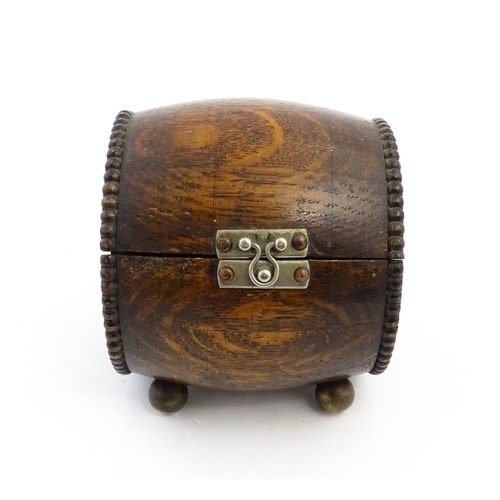 1198 - A 20thC oak cigarette barrel with hinged lid and raised on four feet. Approx. 4 1/4