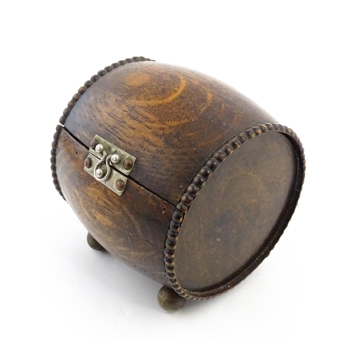 1198 - A 20thC oak cigarette barrel with hinged lid and raised on four feet. Approx. 4 1/4