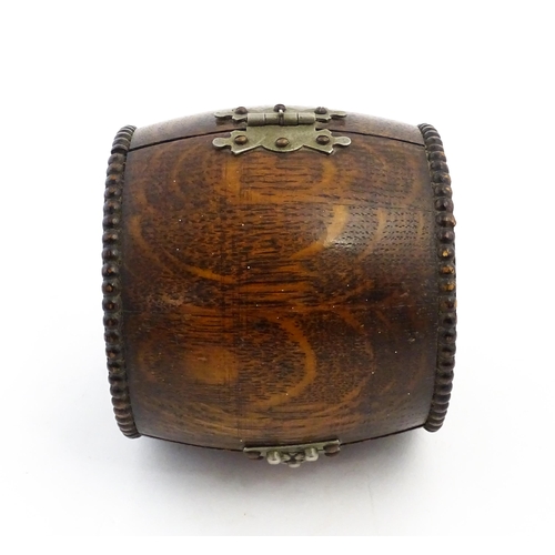 1198 - A 20thC oak cigarette barrel with hinged lid and raised on four feet. Approx. 4 1/4