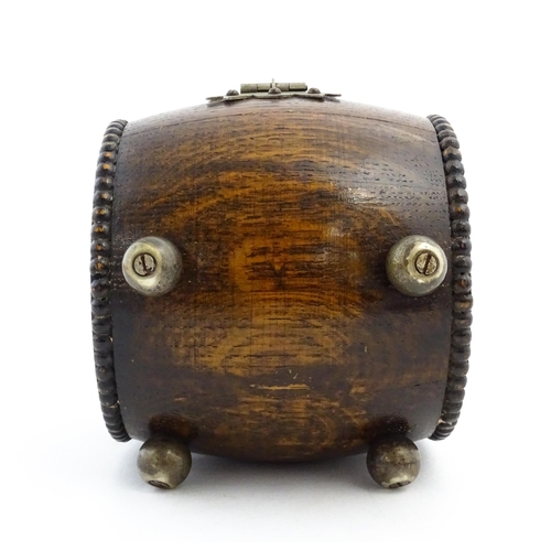 1198 - A 20thC oak cigarette barrel with hinged lid and raised on four feet. Approx. 4 1/4