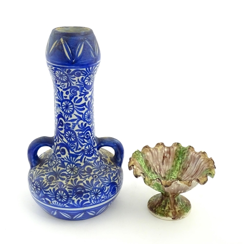 202 - A Moroccan blue and white vase with twin handles decorated with hand painted flowers. Together with ... 