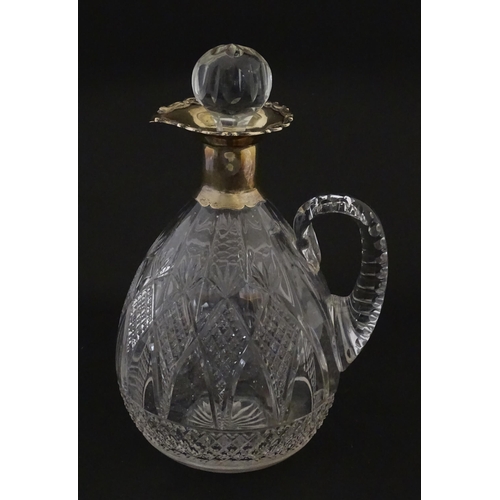 235 - A silver mounted claret jug with cut detail and loop handle. Hallmarked Birmingham 1906 maker Thomas... 