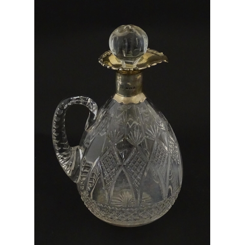 235 - A silver mounted claret jug with cut detail and loop handle. Hallmarked Birmingham 1906 maker Thomas... 