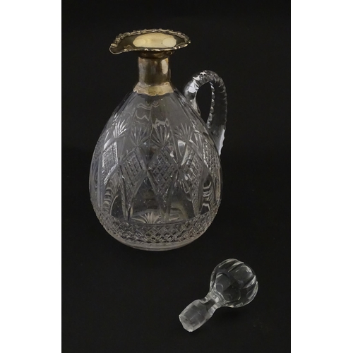 235 - A silver mounted claret jug with cut detail and loop handle. Hallmarked Birmingham 1906 maker Thomas... 