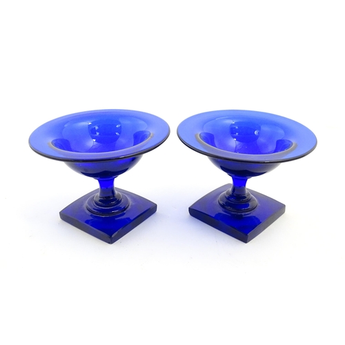 250 - A pair of blue glass pedestal salts with square bases. Approx. 2 1/2