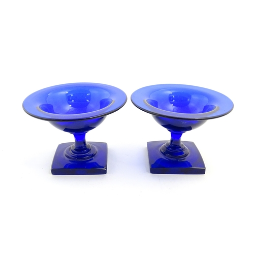 250 - A pair of blue glass pedestal salts with square bases. Approx. 2 1/2