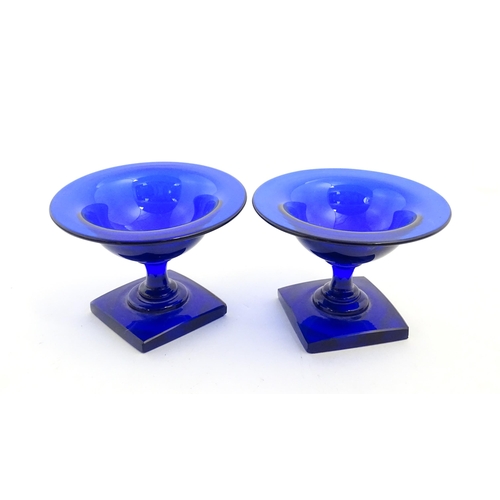 250 - A pair of blue glass pedestal salts with square bases. Approx. 2 1/2