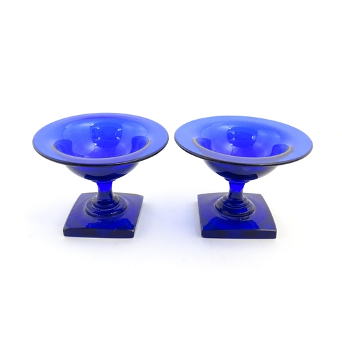 250 - A pair of blue glass pedestal salts with square bases. Approx. 2 1/2