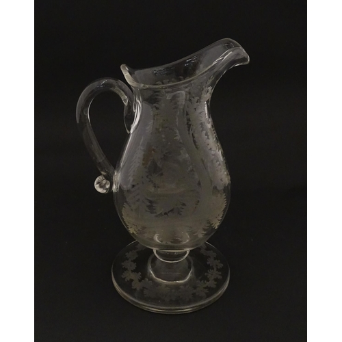 225 - A Victorian glass pitcher / jug with pedestal foot, loop handle and etched a stag and game bird deco... 