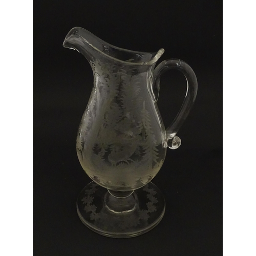 225 - A Victorian glass pitcher / jug with pedestal foot, loop handle and etched a stag and game bird deco... 