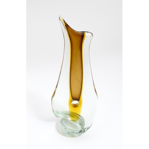 247 - A 20thC studio glass vase of shaped form with orange colouring and a cylindrical hole to centre. App... 