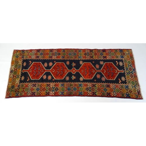 1365 - Carpet / Rug : A North East persian Kurdish Runner. The dark ground decorated with repeating medalli... 