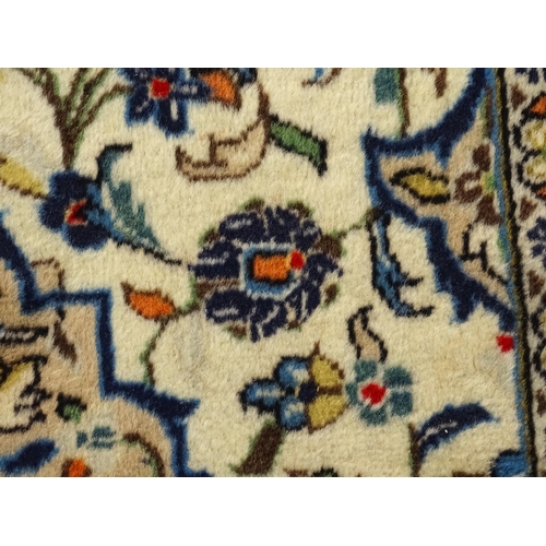 1366 - Carpet / Rug : A Central Persian Kashan rug having cream, and beige grounds decorated with floral an... 