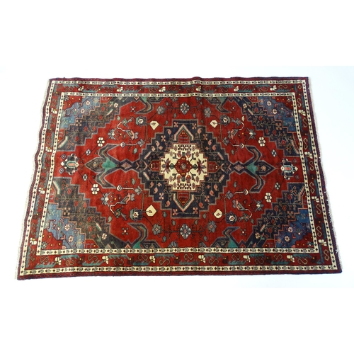 1372 - Carpet / Rug : A  North west Persian Koliahee rug with dark red and blue grounds and central cream g... 