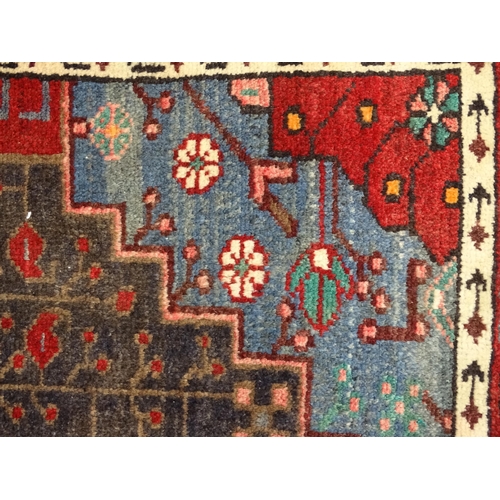 1372 - Carpet / Rug : A  North west Persian Koliahee rug with dark red and blue grounds and central cream g... 