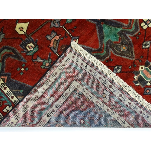 1372 - Carpet / Rug : A  North west Persian Koliahee rug with dark red and blue grounds and central cream g... 