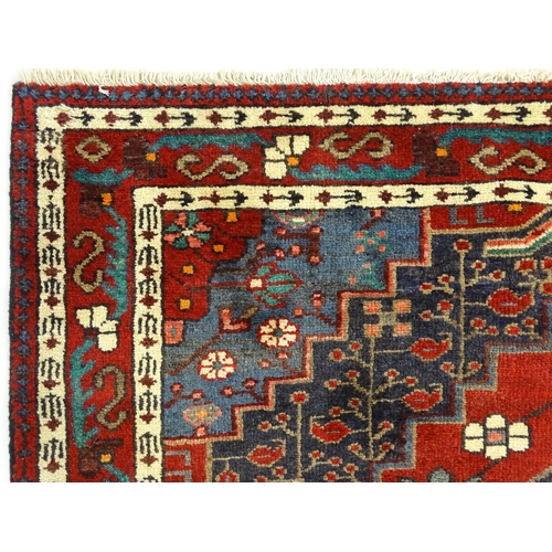 1372 - Carpet / Rug : A  North west Persian Koliahee rug with dark red and blue grounds and central cream g... 