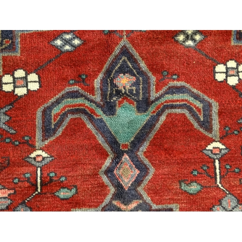 1372 - Carpet / Rug : A  North west Persian Koliahee rug with dark red and blue grounds and central cream g... 