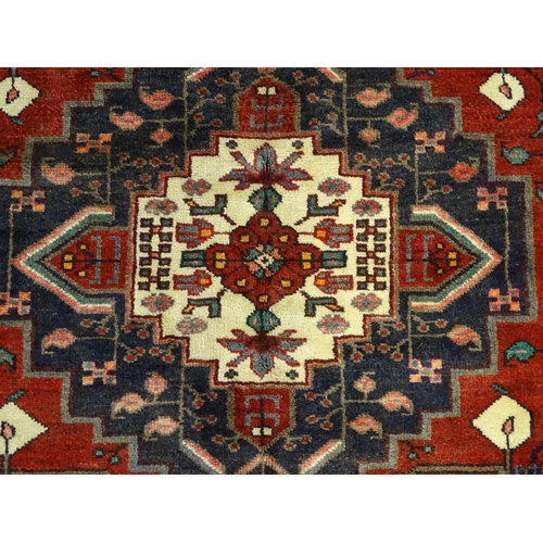 1372 - Carpet / Rug : A  North west Persian Koliahee rug with dark red and blue grounds and central cream g... 