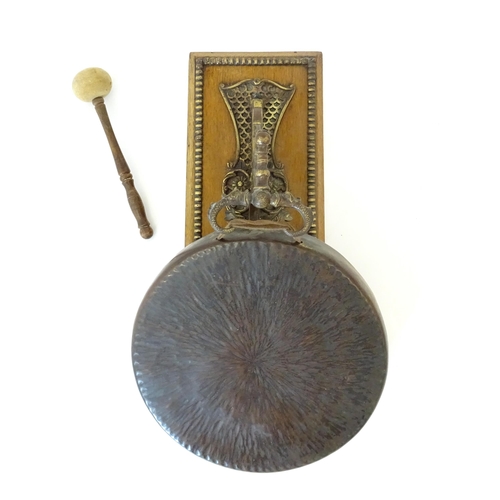 1116 - A 20thC wall mounting gong and beater, the foliate bracket with winged serpent detail. Approx. 19 1/... 