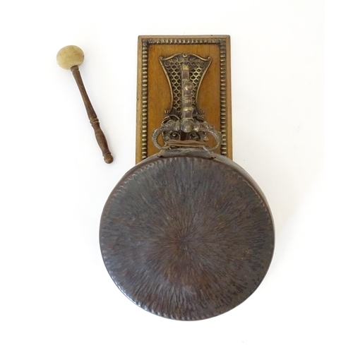 1116 - A 20thC wall mounting gong and beater, the foliate bracket with winged serpent detail. Approx. 19 1/... 