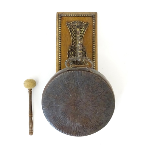 1116 - A 20thC wall mounting gong and beater, the foliate bracket with winged serpent detail. Approx. 19 1/... 