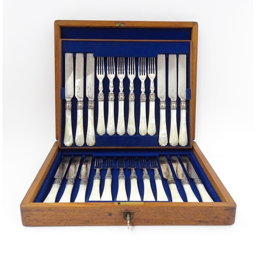 586 - A cased set of six close silver plate fruit knives and forks with mother of pearl handles. 12 1/2