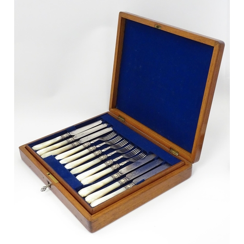 586 - A cased set of six close silver plate fruit knives and forks with mother of pearl handles. 12 1/2