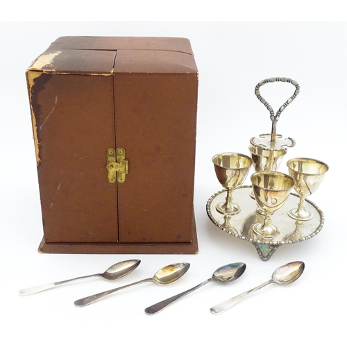 592 - A cased silver plate egg cruet comprising four egg cups, four spoons and a stand. Approx. 8 1/2