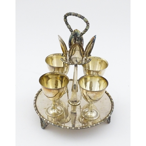 592 - A cased silver plate egg cruet comprising four egg cups, four spoons and a stand. Approx. 8 1/2