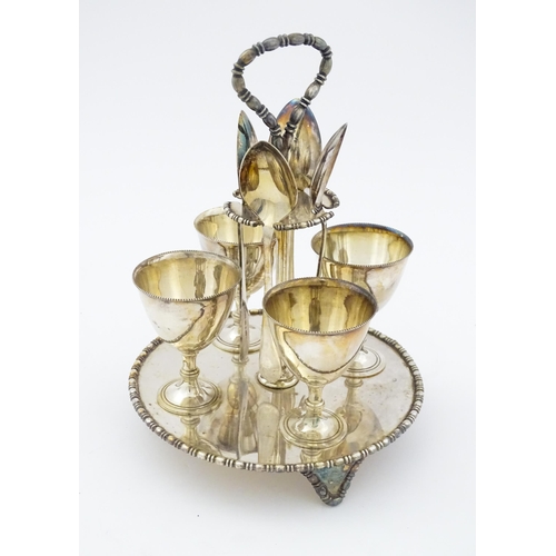 592 - A cased silver plate egg cruet comprising four egg cups, four spoons and a stand. Approx. 8 1/2