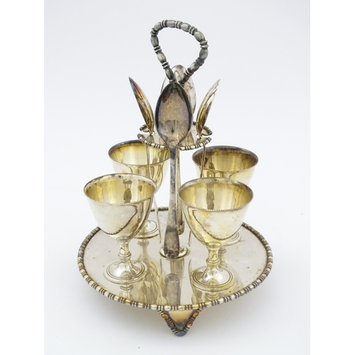 592 - A cased silver plate egg cruet comprising four egg cups, four spoons and a stand. Approx. 8 1/2