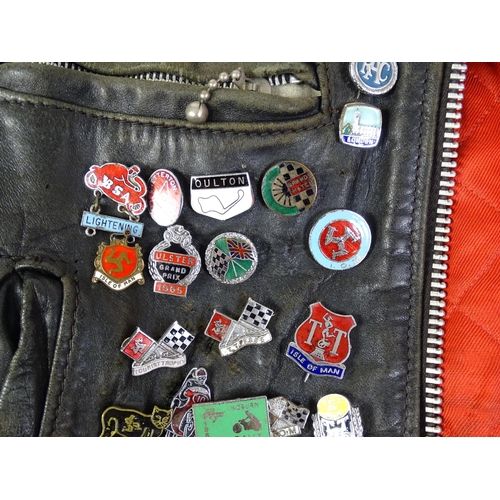 1287 - Vintage fashion / clothing: A vintage black leather biker jacket with a quantity of collectors badge... 