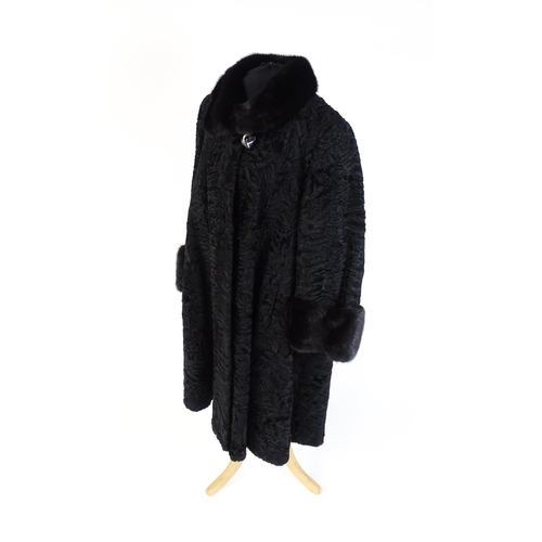 1302 - Vintage fashion / clothing: A black Persian lamb / Astrakhan coat with fur to collar and cuffs. Labe... 