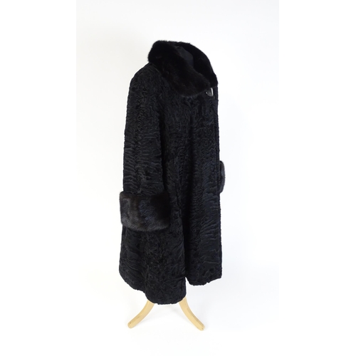 1302 - Vintage fashion / clothing: A black Persian lamb / Astrakhan coat with fur to collar and cuffs. Labe... 