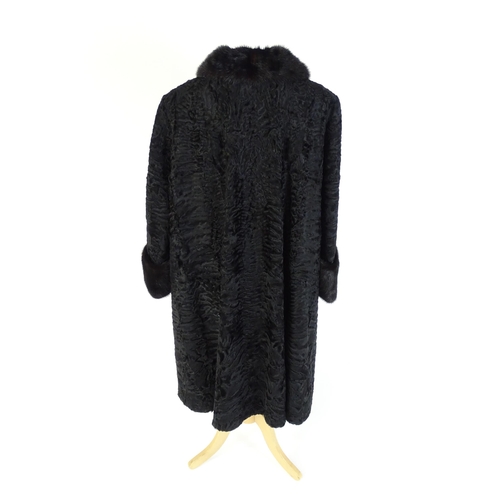 1302 - Vintage fashion / clothing: A black Persian lamb / Astrakhan coat with fur to collar and cuffs. Labe... 