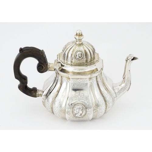 279 - A Victorian silver teapot with engraved decoration and oval figural bust detail. Hallmarked London 1... 