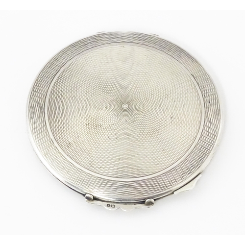 292 - A silver compact with engine turned decoration hallmarked Birmingham 1920, maker W I Broadway & Co. ... 