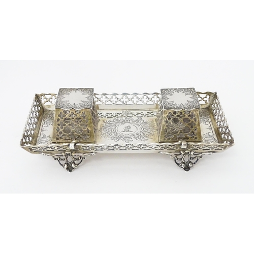 295 - A Victorian silver standish with twin ink bottles, galleried sides and raised on four feet, hallmark... 