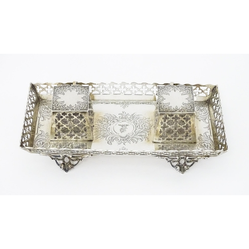 295 - A Victorian silver standish with twin ink bottles, galleried sides and raised on four feet, hallmark... 