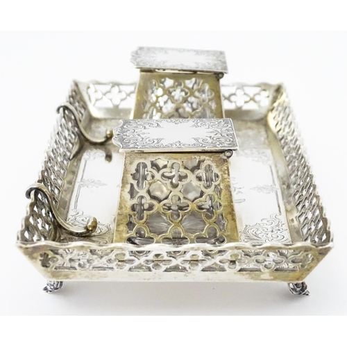 295 - A Victorian silver standish with twin ink bottles, galleried sides and raised on four feet, hallmark... 