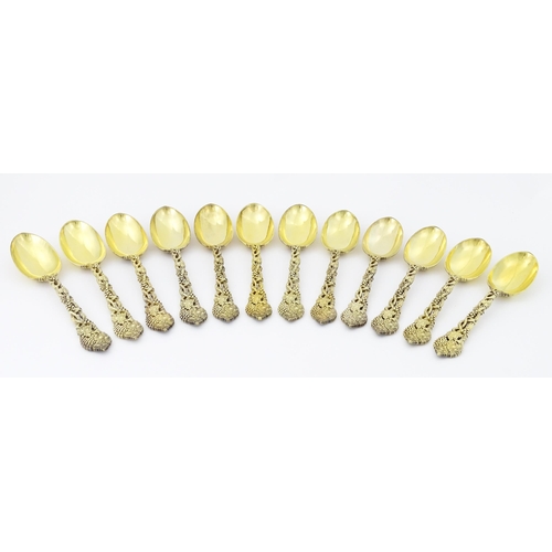 298 - A set of twelve Victorian silver gilt dessert spoons with fruiting vine detail to handles, hallmarke... 