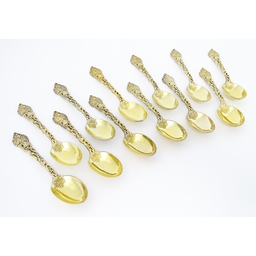 298 - A set of twelve Victorian silver gilt dessert spoons with fruiting vine detail to handles, hallmarke... 