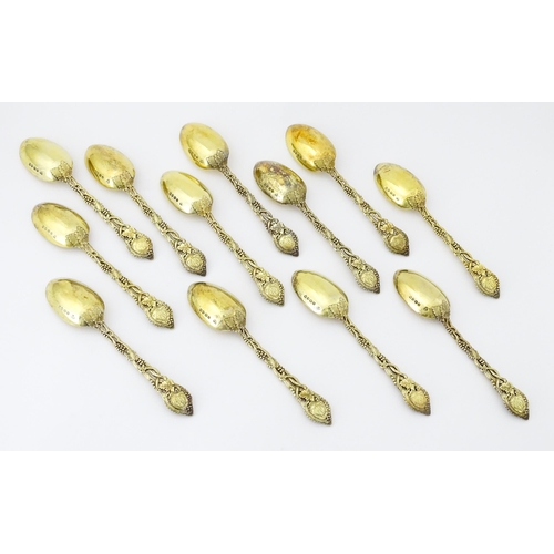 298 - A set of twelve Victorian silver gilt dessert spoons with fruiting vine detail to handles, hallmarke... 