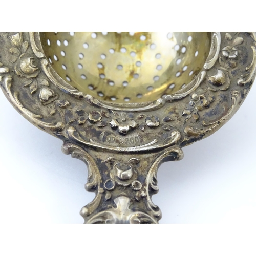 314 - A German .800 silver tea / lemon strainer with embossed decoration. Approx. 4 1/4