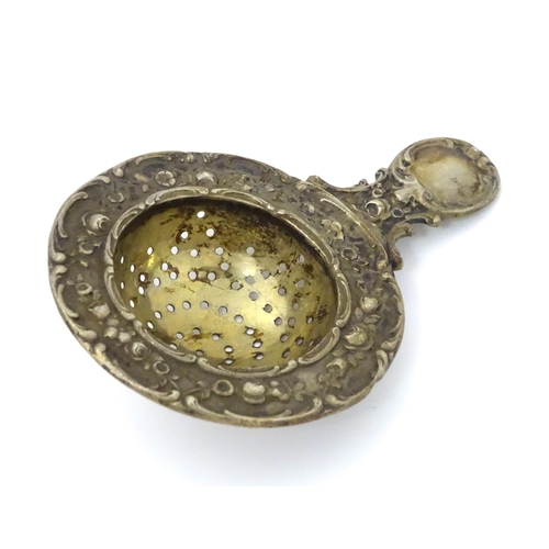 314 - A German .800 silver tea / lemon strainer with embossed decoration. Approx. 4 1/4