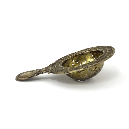 314 - A German .800 silver tea / lemon strainer with embossed decoration. Approx. 4 1/4