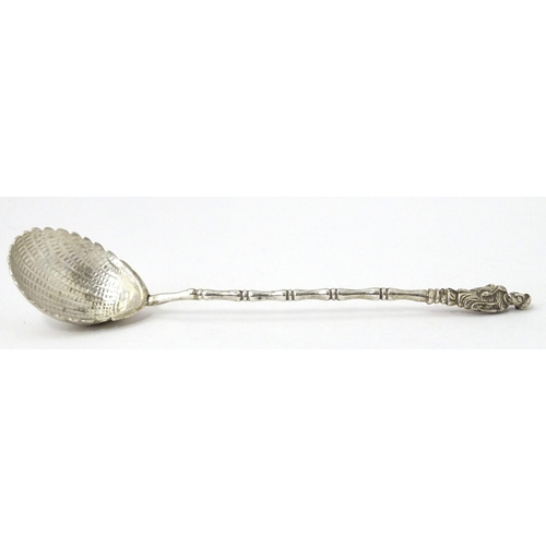 315 - A Chinese Export silver spoon with shell formed bowl and stylised bamboo handle surmounted by an Ori... 