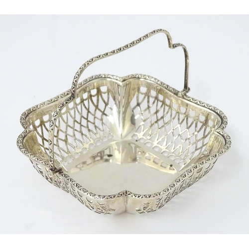 322 - A silver bon bon dish with pierced decoration and swing handle, hallmarked London 1913, maker John C... 